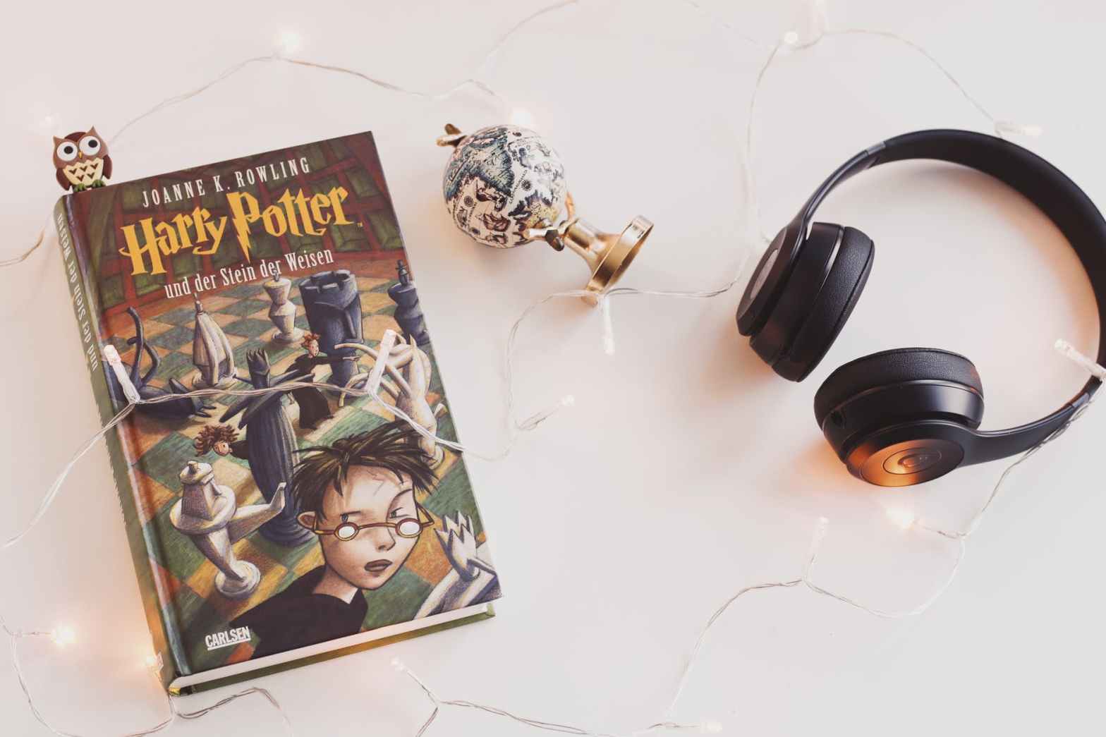 harry potter book and black headphones with trinket